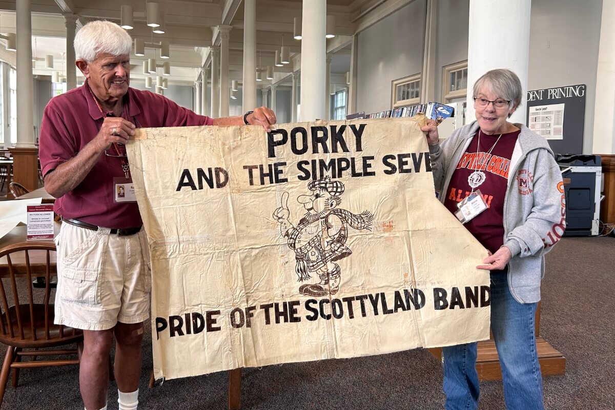 Photo of Rob Kennedy and Diane Edwards holding up a banner for the long-gone Maryville College music ensemble Porky and the Simple Seven