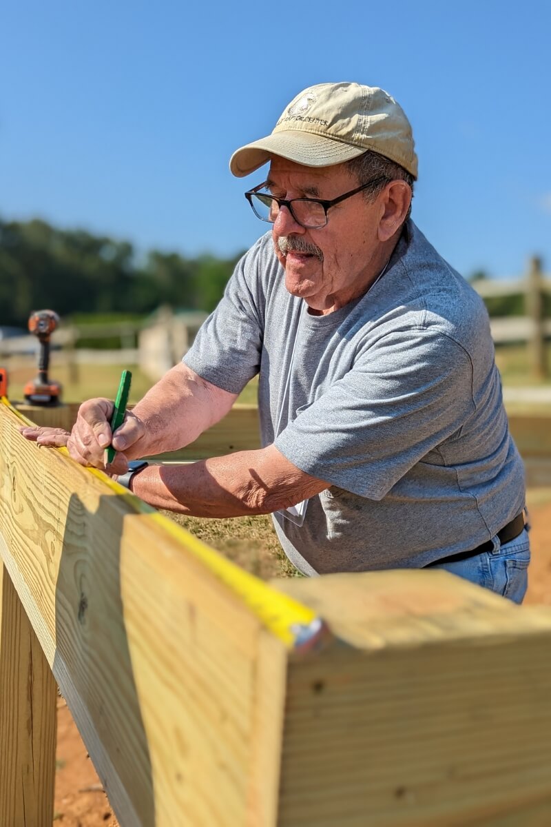 Photo of Ross Hamory measuring lumber for a KT Days project at Maryville College in 2023.