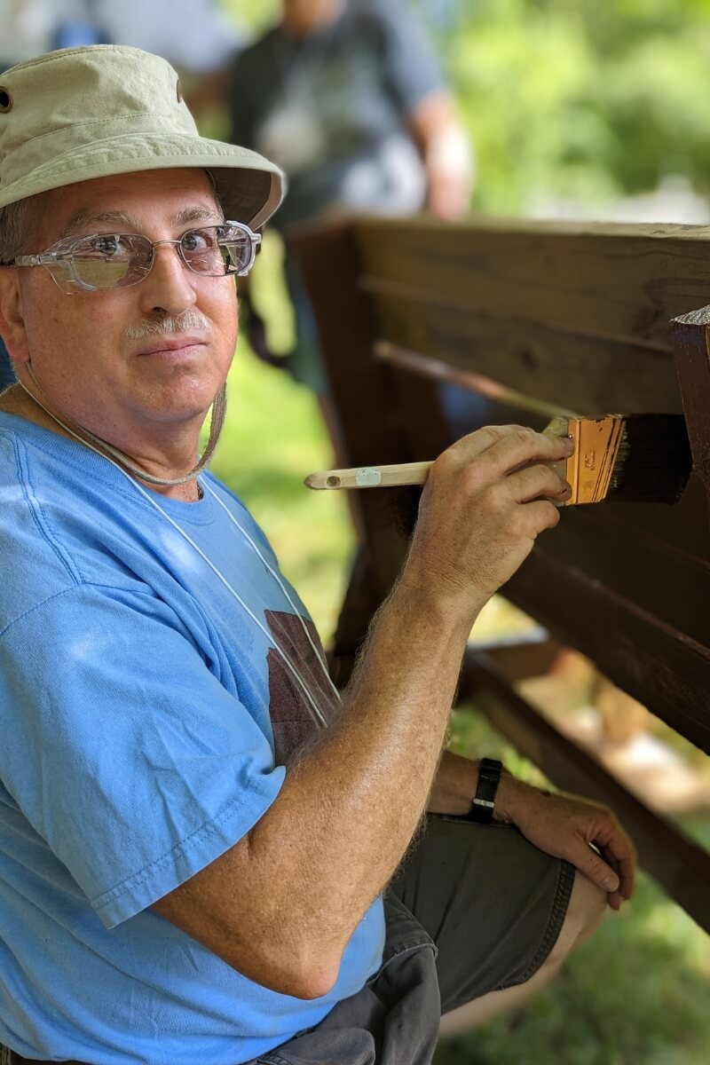 Photo of a Maryville College alumna's husband painting a bench during KT Days 2023