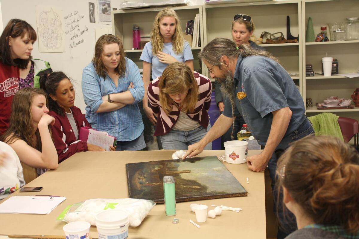Photo of Carl Gombert surrounded by students