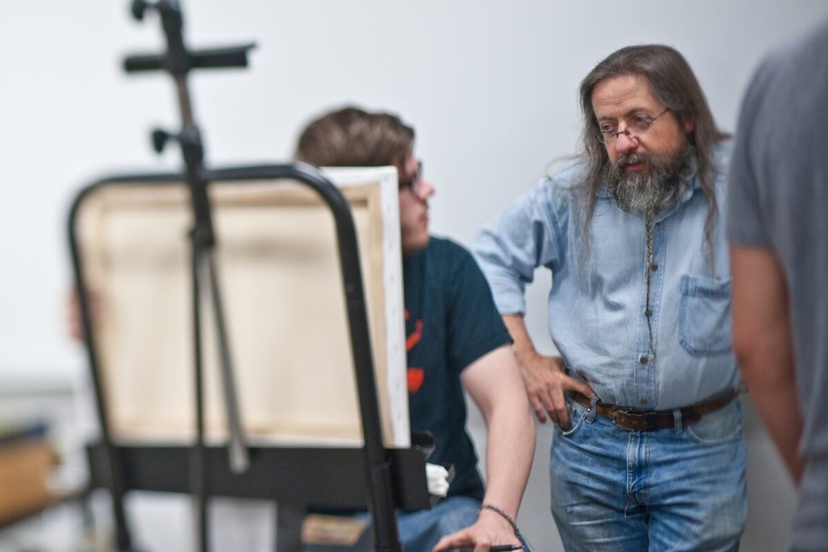 Photo of Carl Gombert working with student