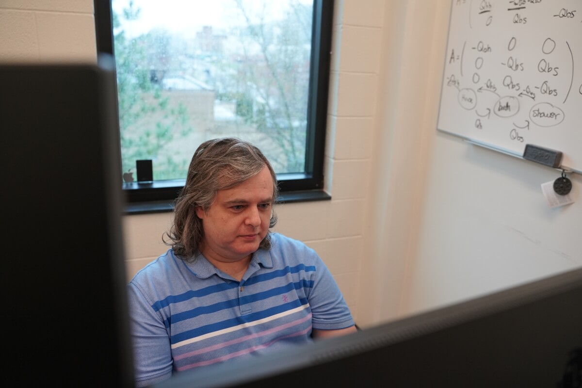 Photo of Dr. Jesse Smith '08 sitting at a computer