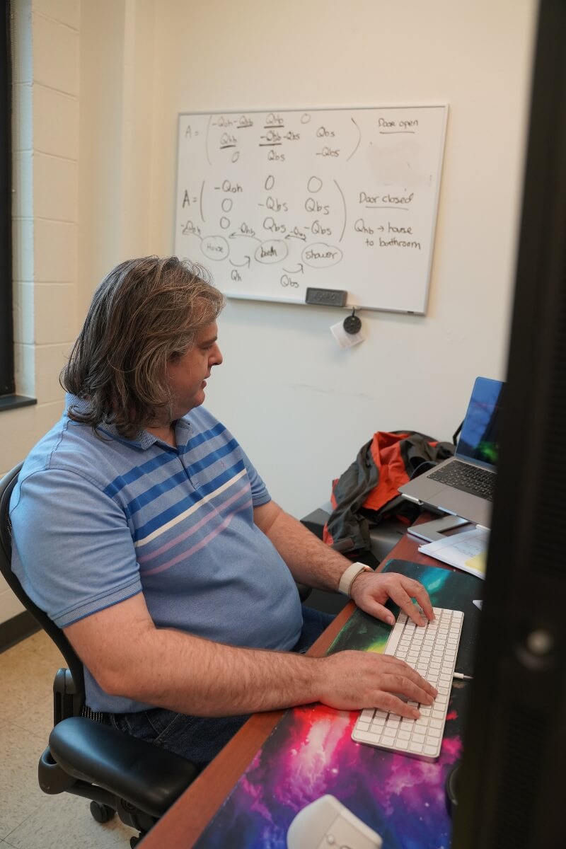 Photo of Dr. Jesse Smith '08 at his ORNL workstation.