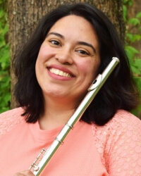 Photo of a smiling Nathalie Simper holding a flute