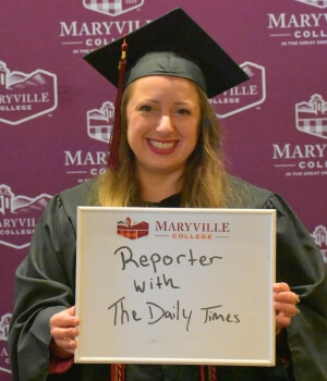 Photo of Shanon Adame '24 holding a white board