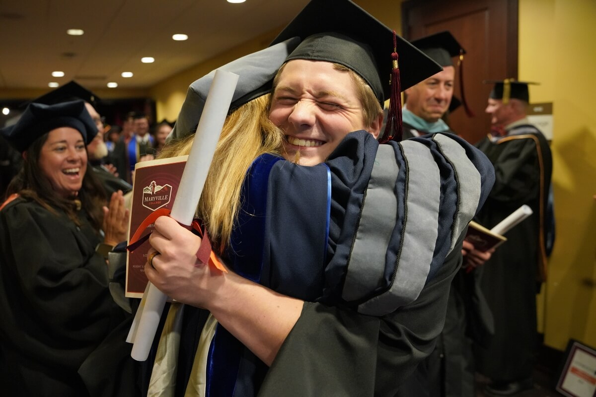 Photo of a graduate hugging a family member