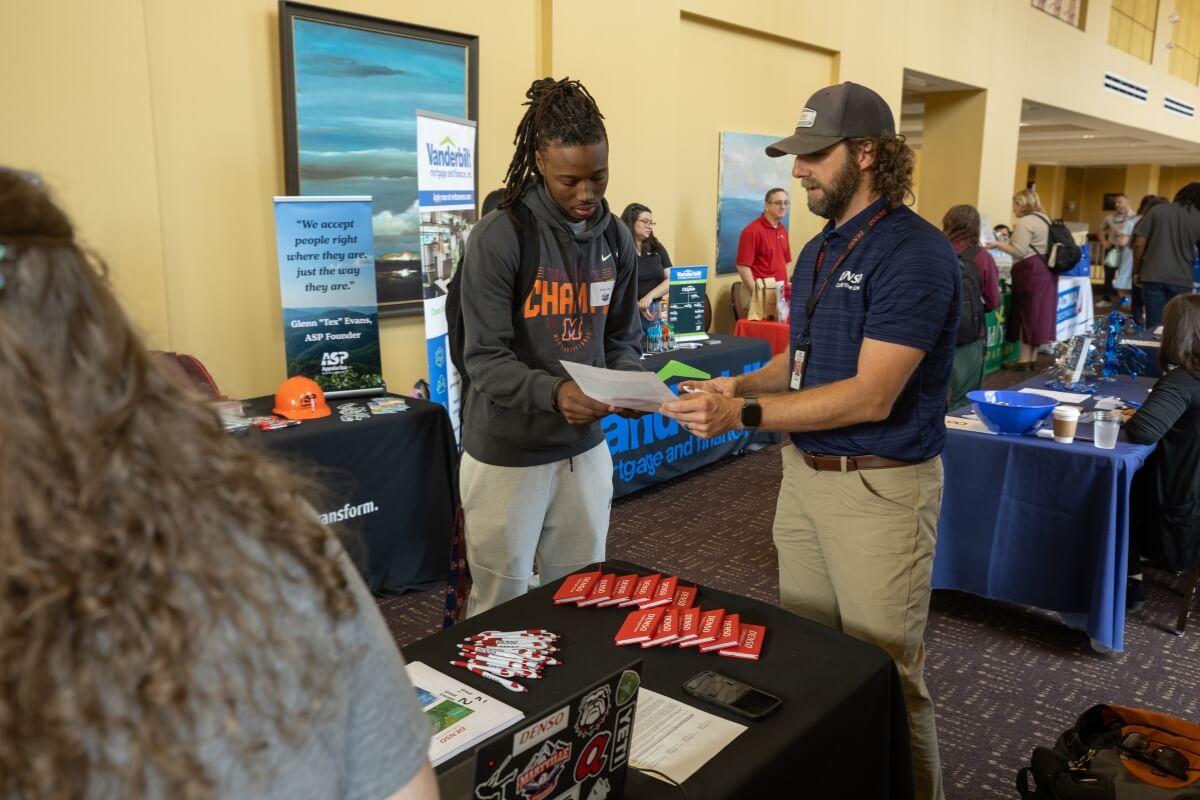 Photo of a student talking with a business representative at the Maryville College Career Fair