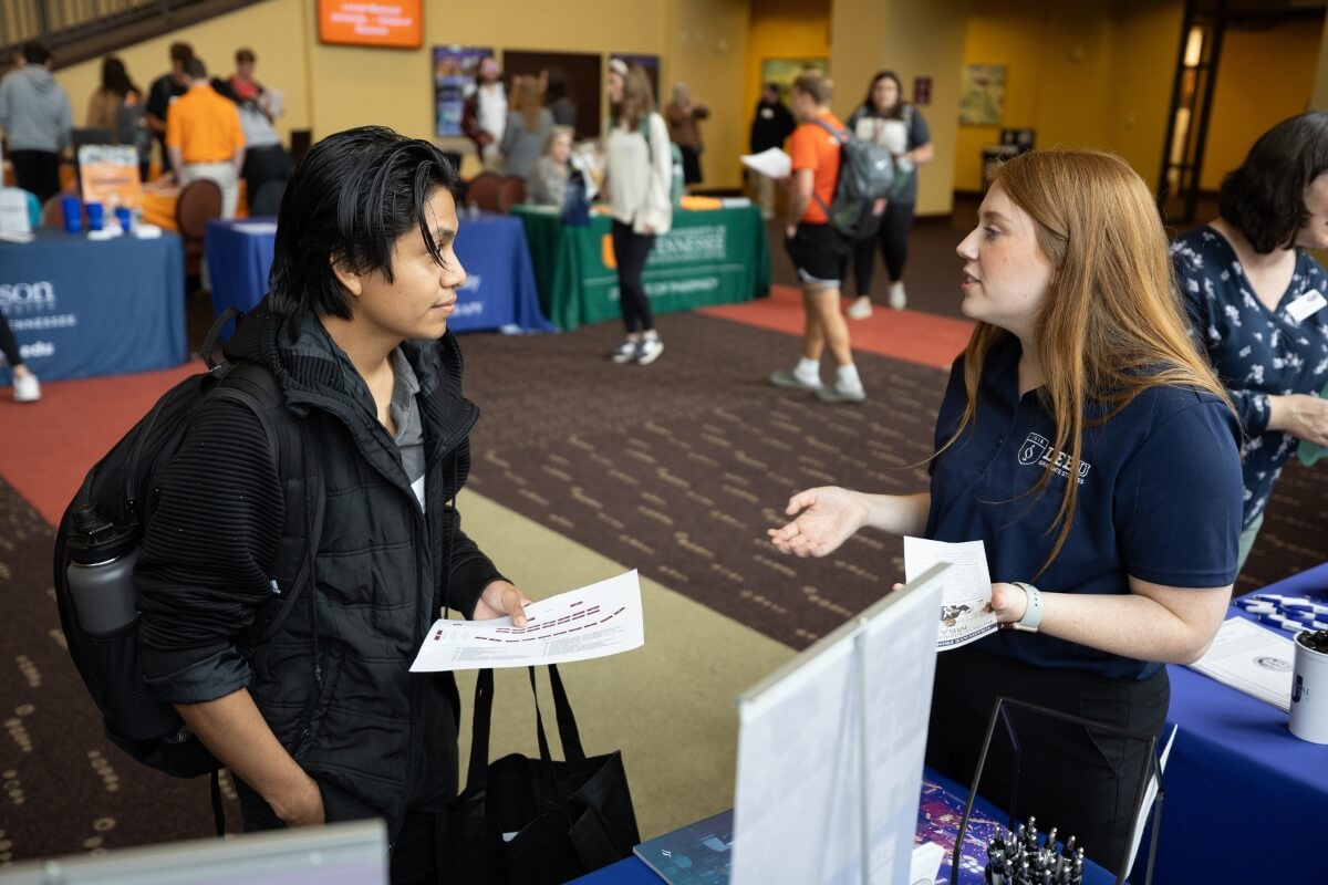 Photo of a Lee University representative talking to a student at the Maryville College Graduate School Fair