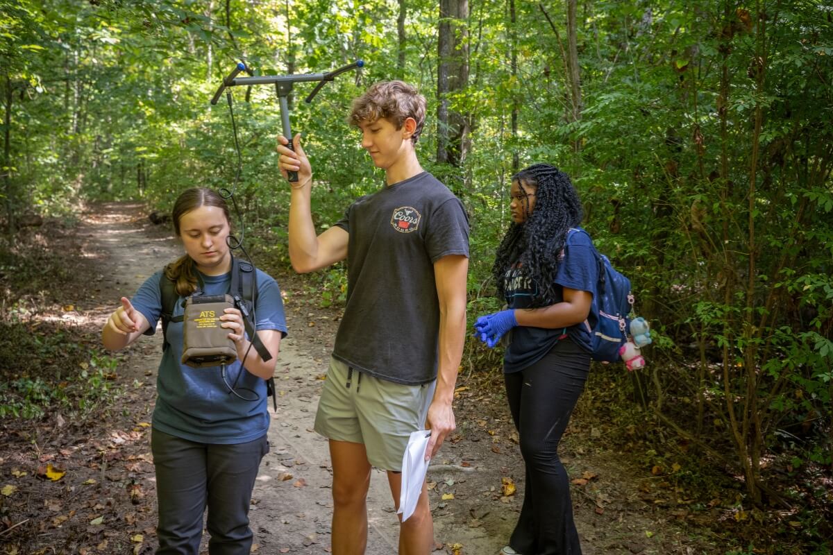 Photo of students searching for turtles using telemetry in the MC Woods