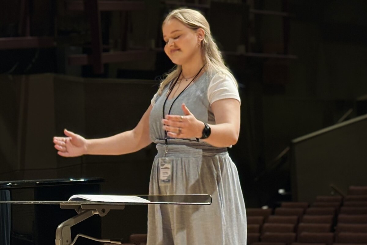 Photo of Elaina Wilson smiling and conducting