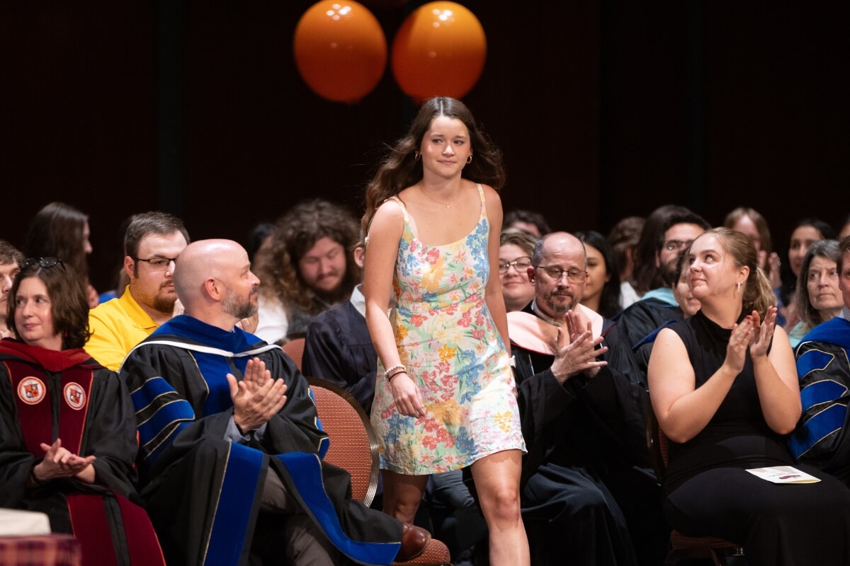Photo of Maryville College LeQuire Award winner Grace McDonald walking to the front of a podium