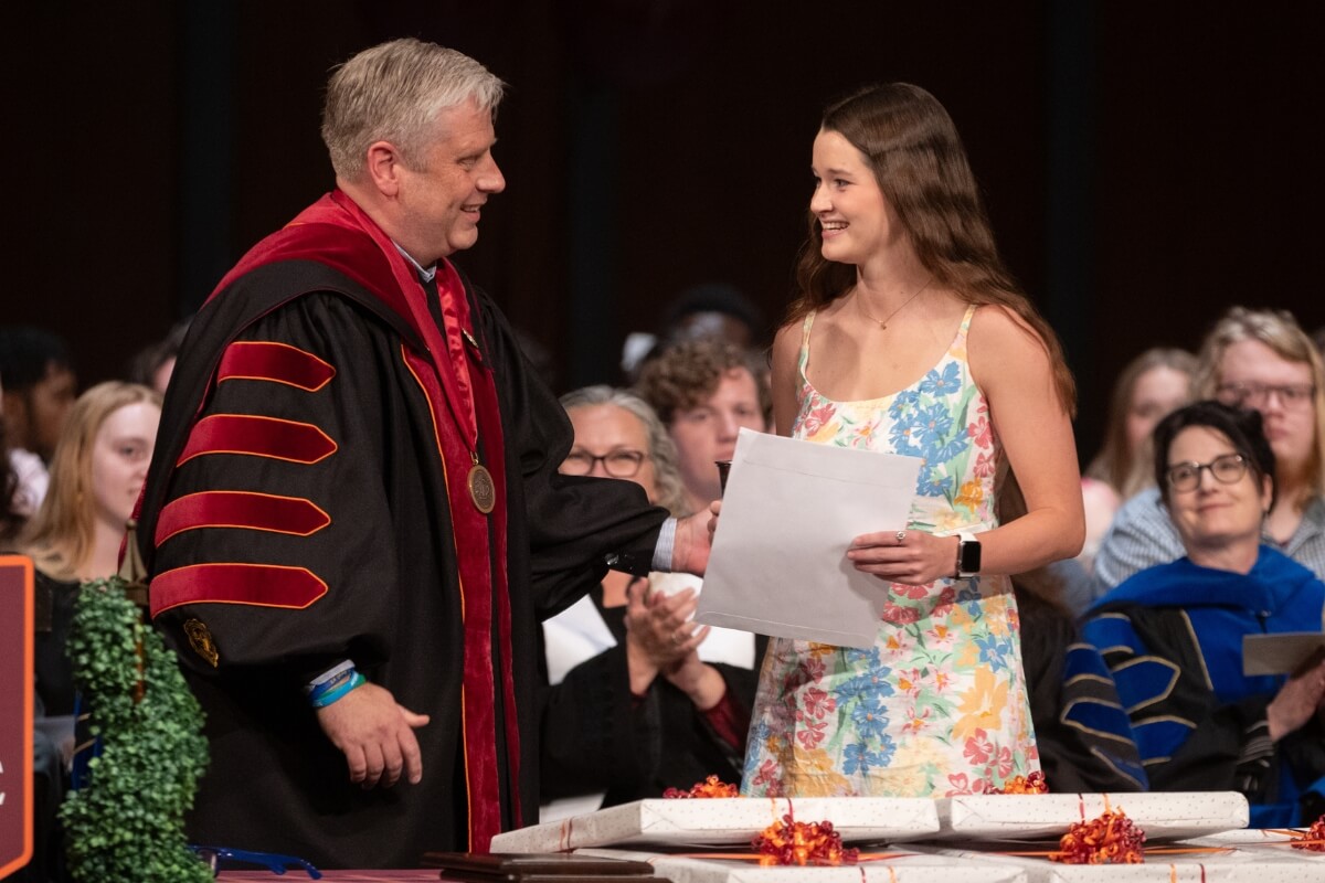 Photo of Maryville College President Bryan Coker chatting with Grace McDonald during an awards presentation