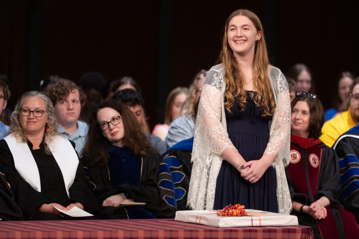 Photo of a girl with long hair looking to her left and smiling