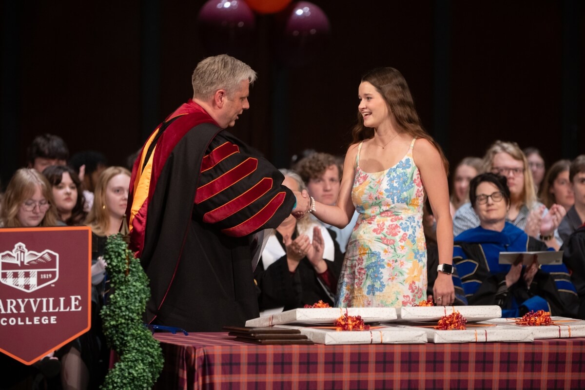 Photo of Dr. Bryan Coker giving a prestigious award to Grace McDonald