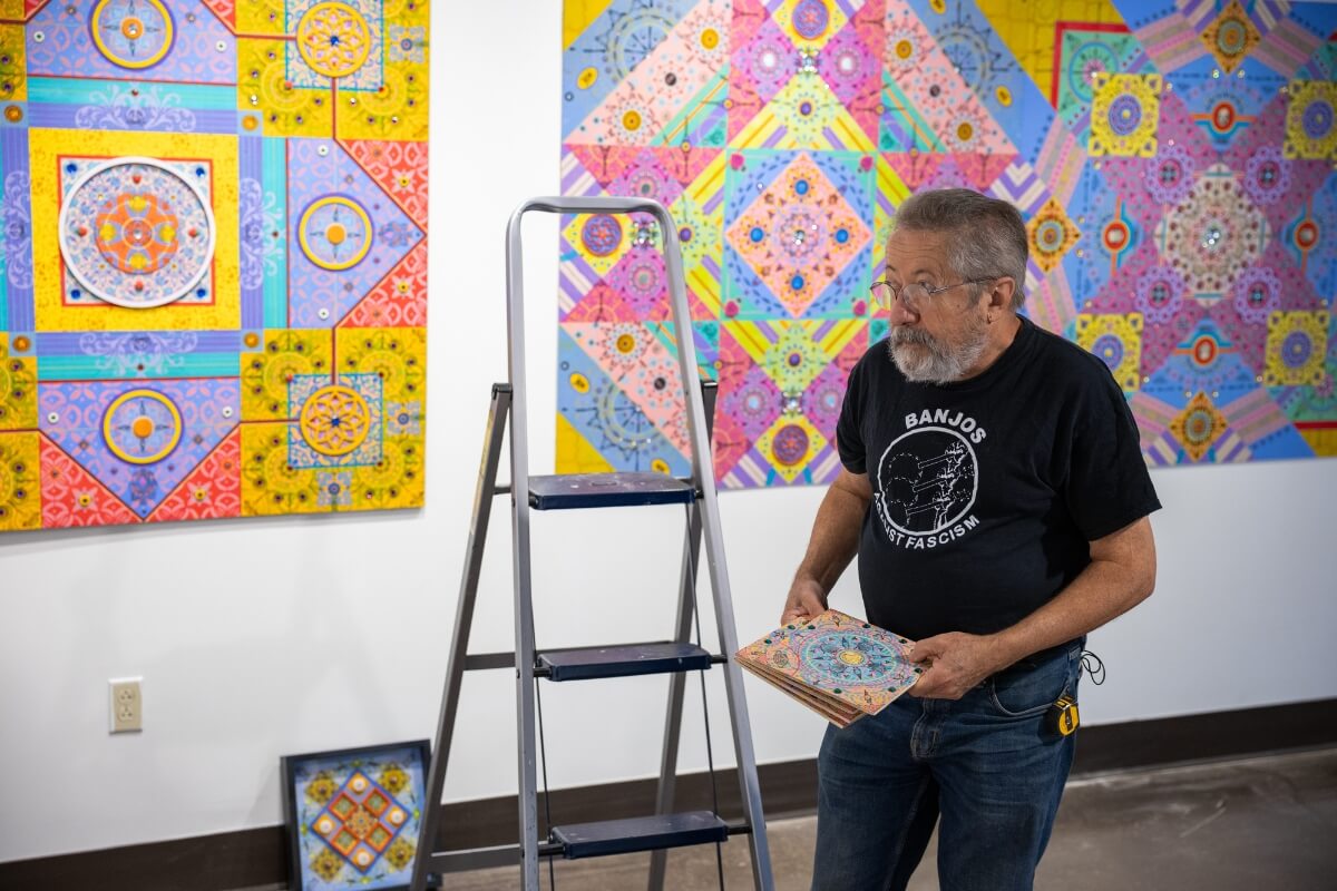 Photo of Dr. Carl Gombert looking through his own works of art.