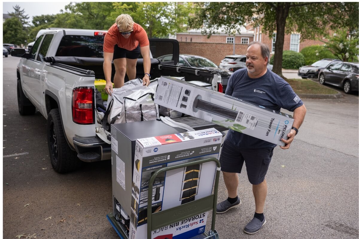 Photo of a family unloading things from the back of a pickup truck.