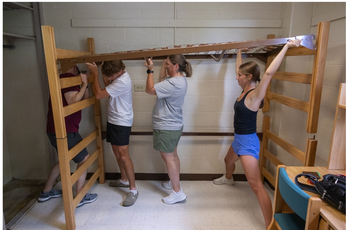 Photo of a family assembling a bed in a dorm room