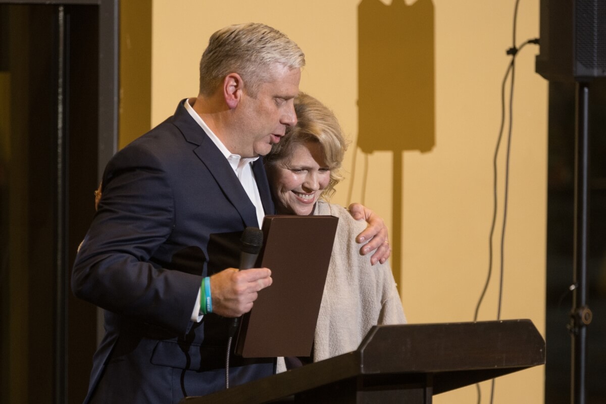 Photo of MC President Dr. Bryan Coker hugging artist Lindy Harris Bruggink '72