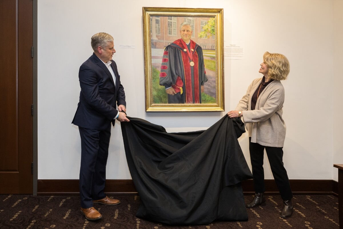 Photo of Bryan Coker and Lindy Bruggink unveiling the presidential portrait