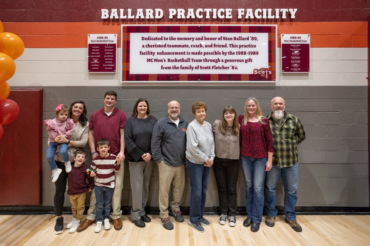 Photo of the family of Stan Ballard '89 beneath the sign of the Ballard Practice Facility