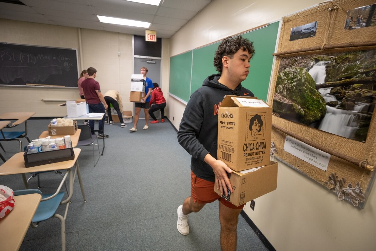 Photo of a Maryville College student carrying a box