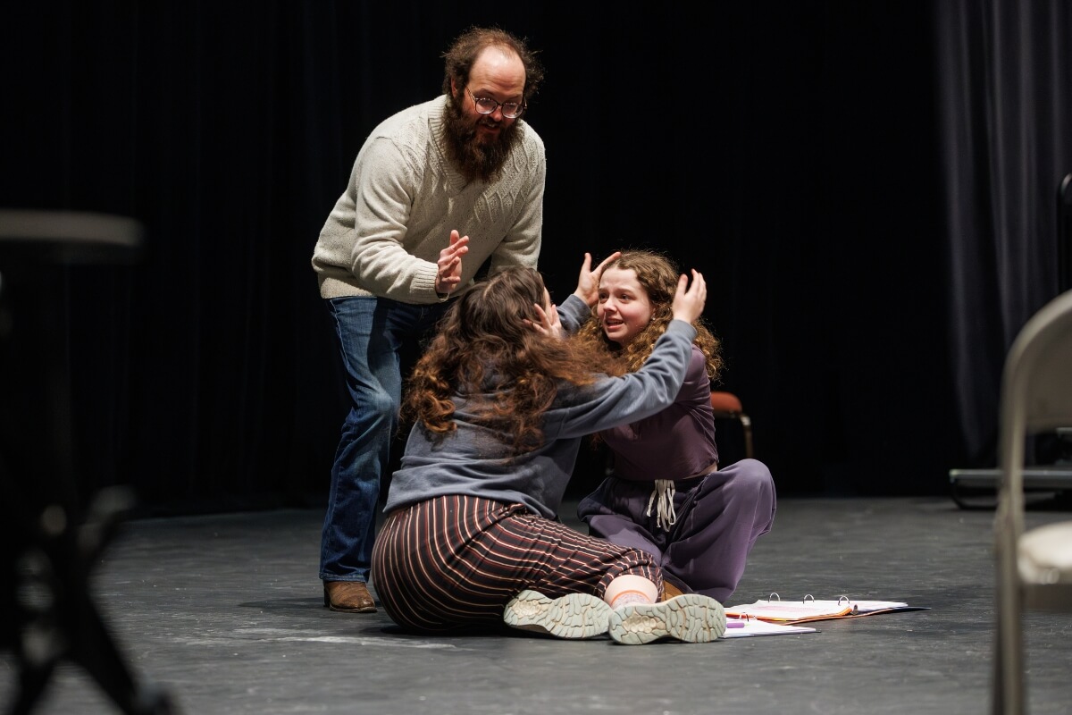 Photo of Andy Vaught coaching two actors through a scene