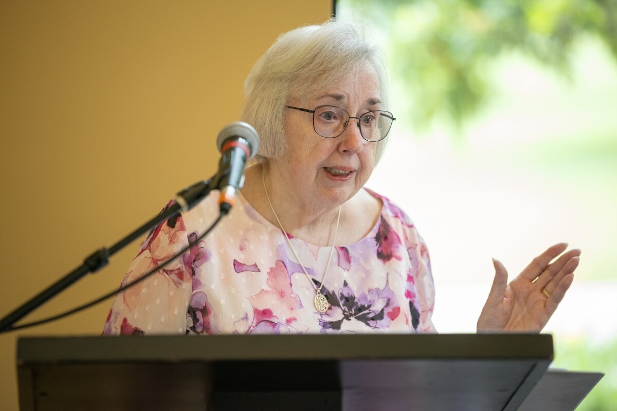 Photo of Sally Gross speaking to the assembled crowd at the ribbon-cutting for the Doug and Sally Gross Memorial Garden