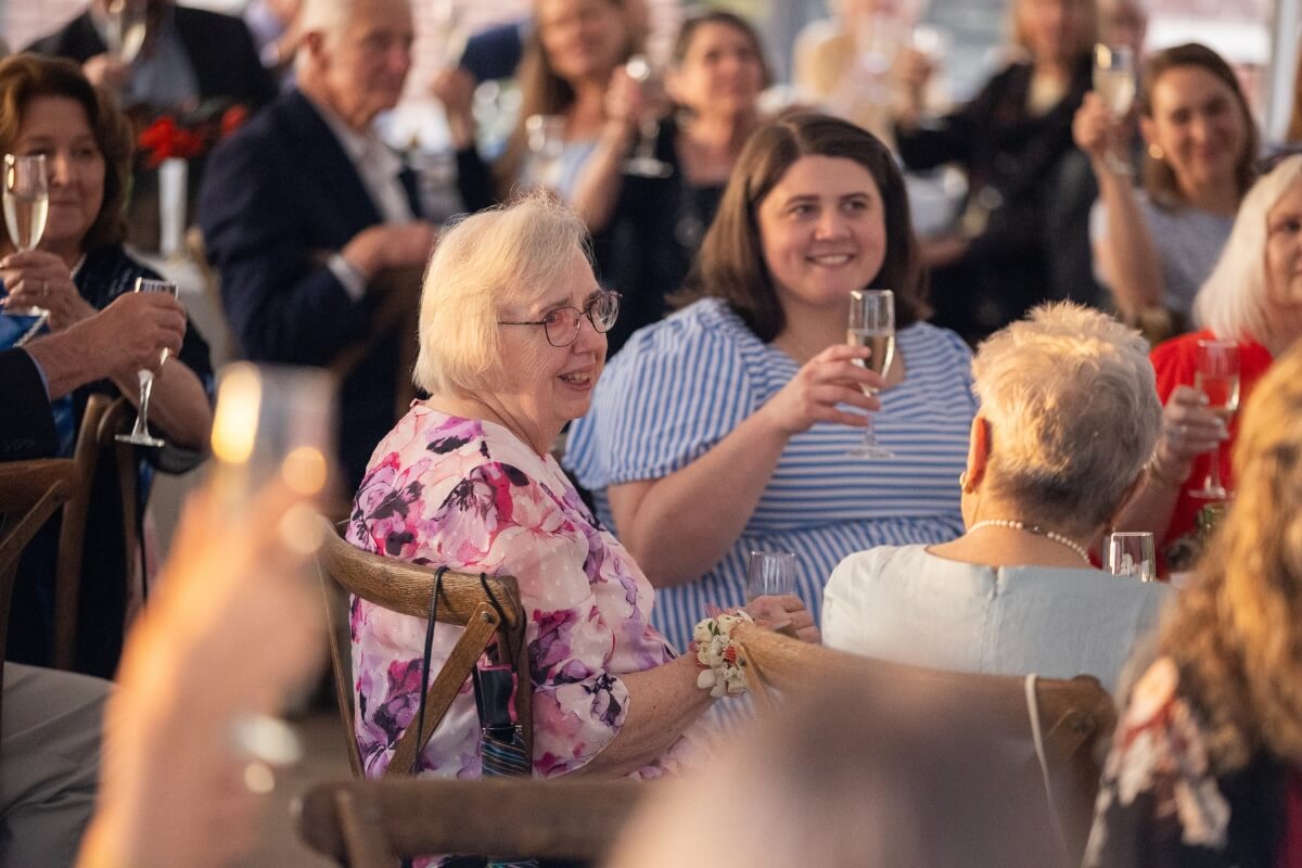 Photo of Sally Gross seated at a table with Clayton Center patrons during the facility's 15th anniversary gala