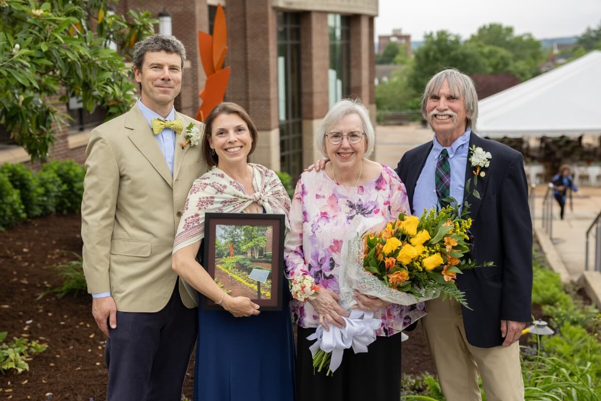 Photo of Sally Gross and three family members in front of the Doug and Sally Gross memorial garden.