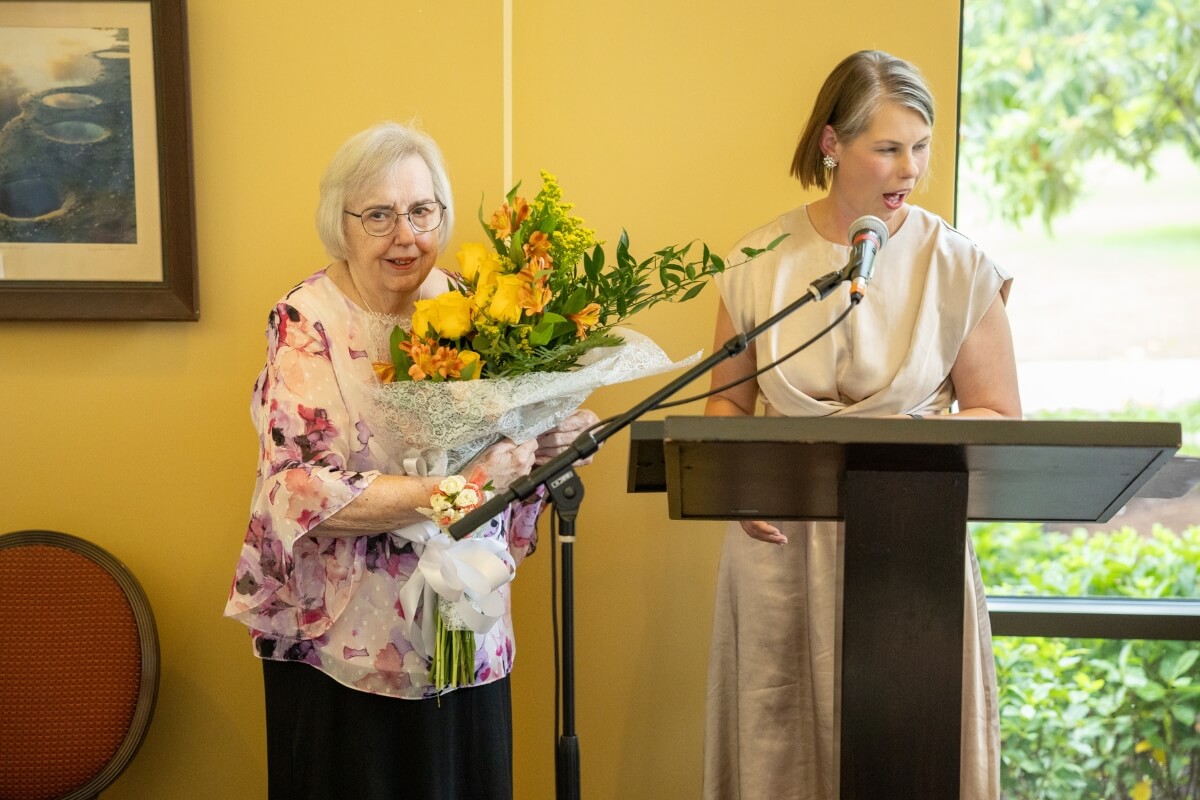 Photo of Clayton Center interim executive director recognizing Sally Gross at a podium