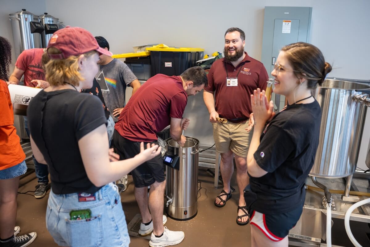 Photo of folks gathered in the Maryville College Downtown Center during a beer-making event.