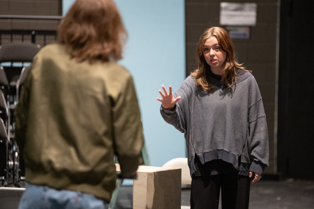 Photo of a female actor in Maryville College's "Angels in America" acting while facing another actor with back to camera