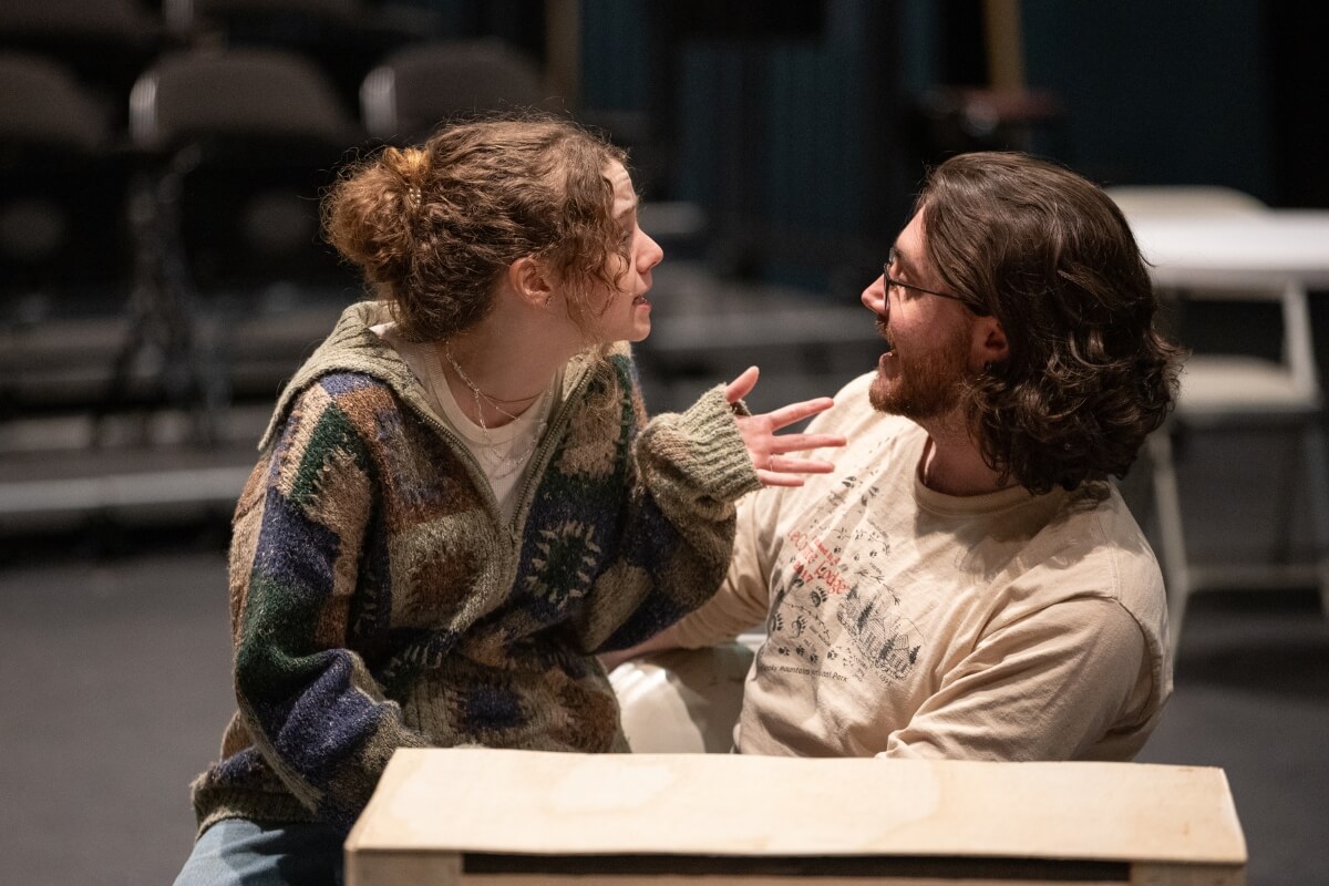 Photo of two Maryville College students talking intimately during a scene from "Angels in America"