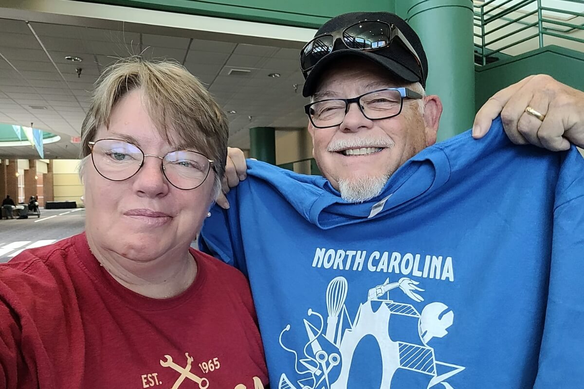 Photo of MC staffer Tammy Brown and her husband, who's holding up a blue T-shirt
