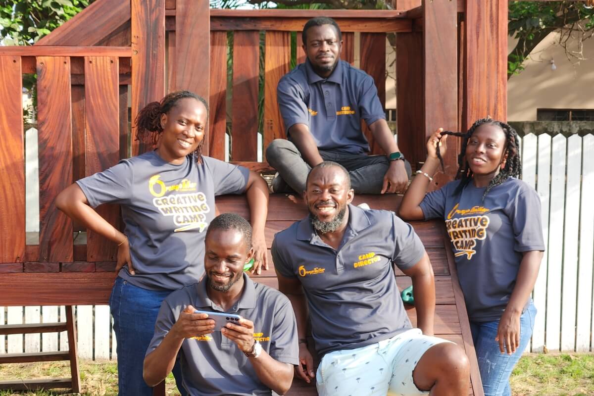 Photo of five Black people on a wooden playground apparatus in Ghana