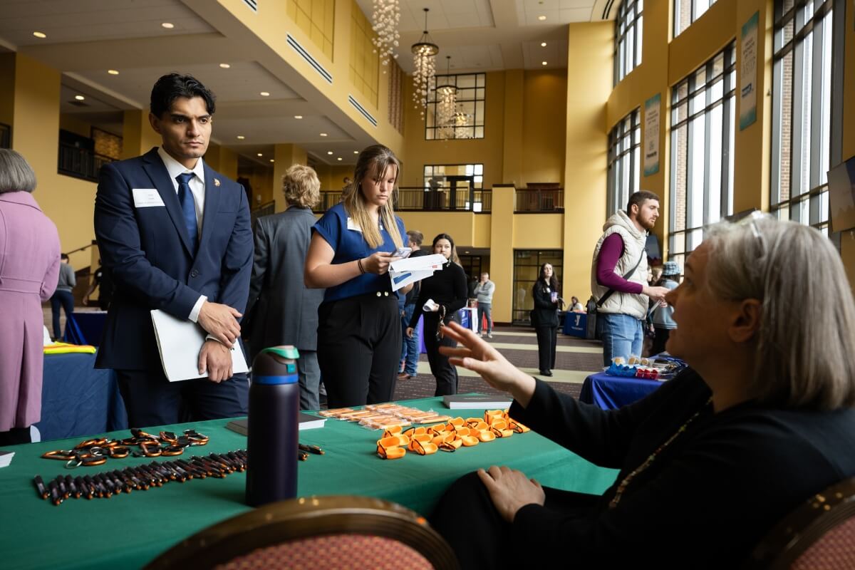 Photo of a student listening to a representative at the Spring Opportunities Fair