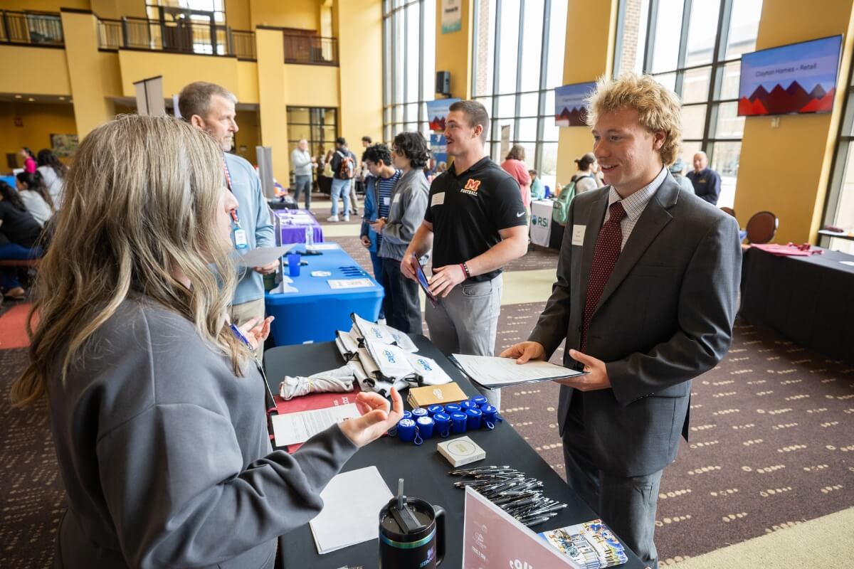 Photo of a Maryville College student talking with a Clayton representative at the Spring Opportunities Fair