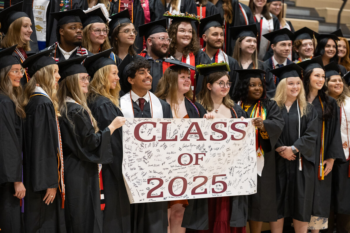 Photo of Maryville College Commencement 2025 seniors holding the senior banner and posing for a photo
