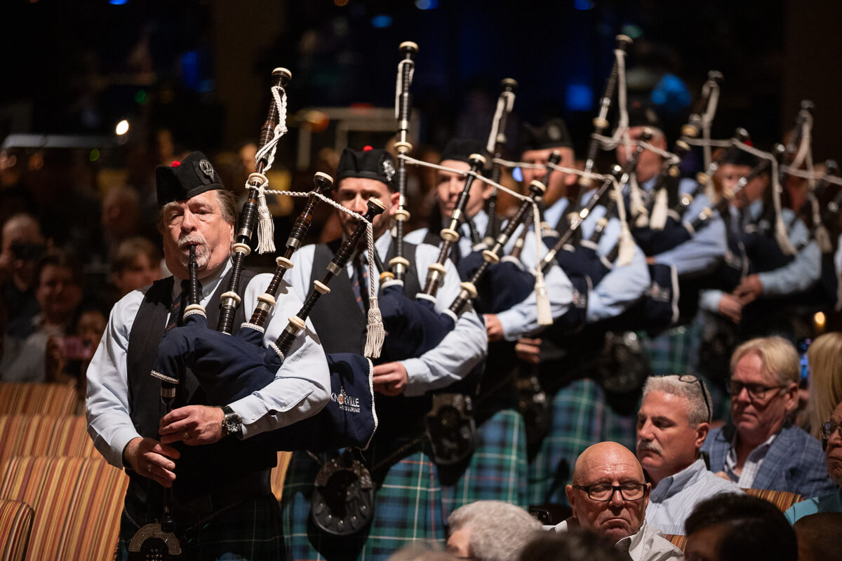 Photo of a pipes and drums band marching