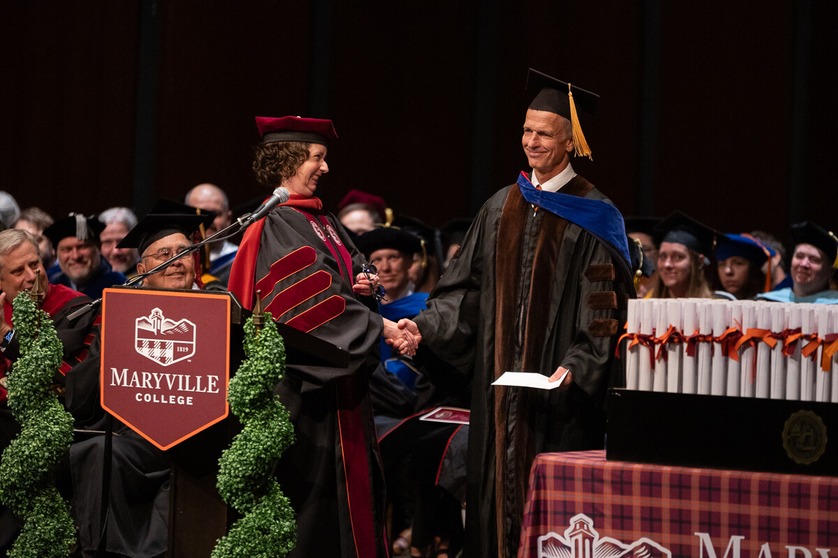 Photo of Dr. Liz Perry-Sizemore congratulating a smiling Dr. Jeff Bay on being named Outstanding Teacher of the Year