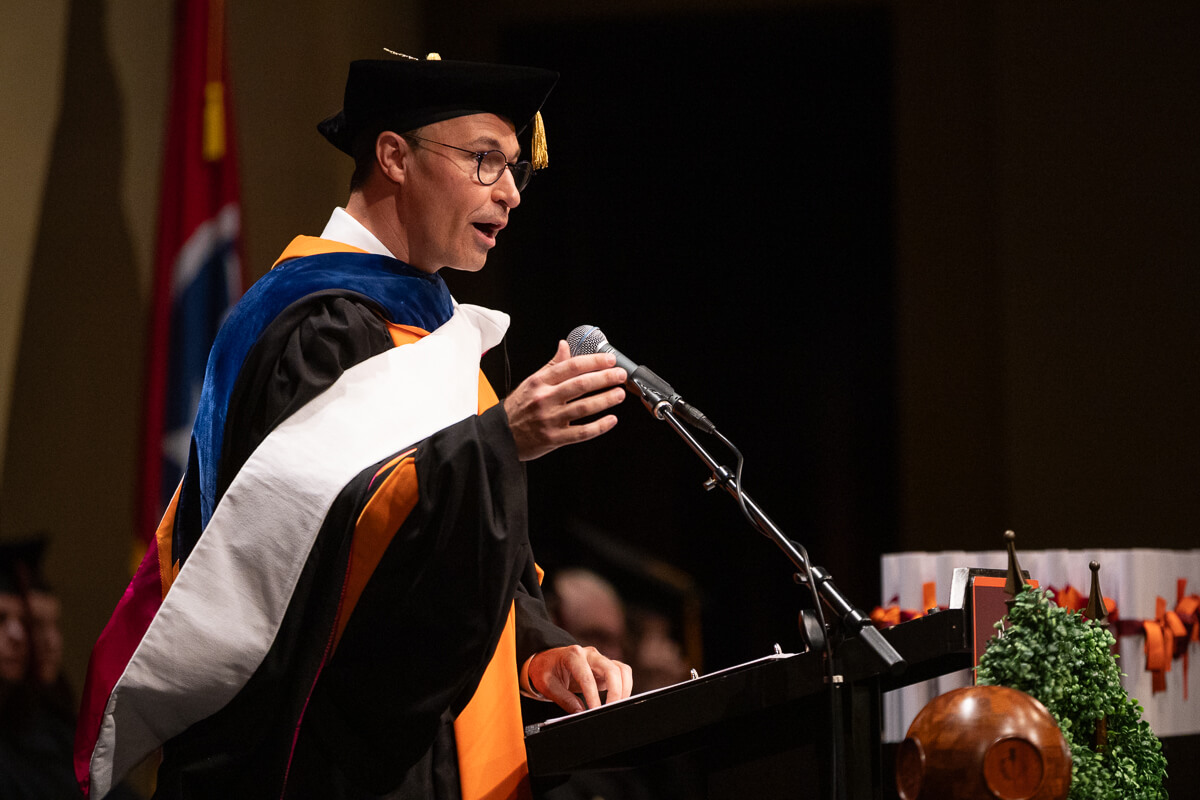 Photo of Dr. Michael Lamb gesturing while speaking at a podium