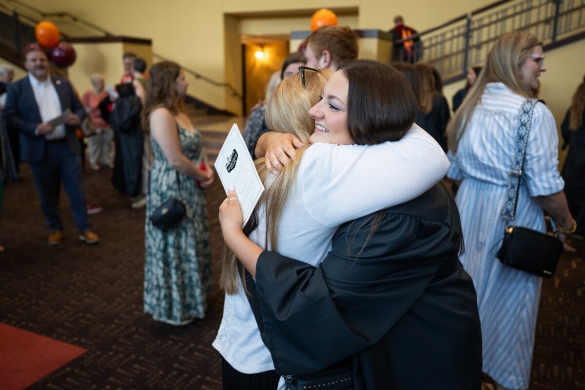 Photo of two people embracing in the Clayton Center for the Arts foyer