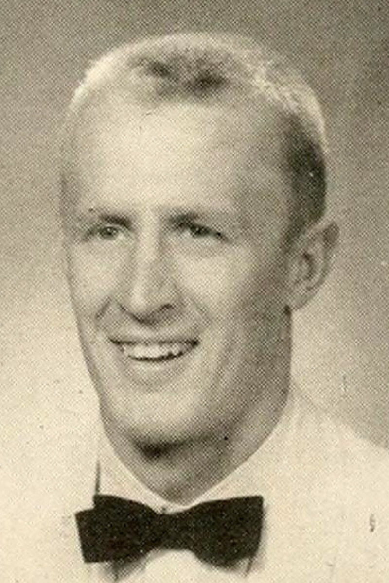 Black and white photo of a man wearing a bow tie and smiling at the camera