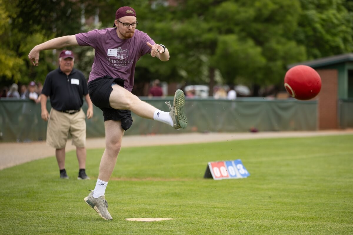 Photo of a guy awkwardly kicking a ball during a game of kickball