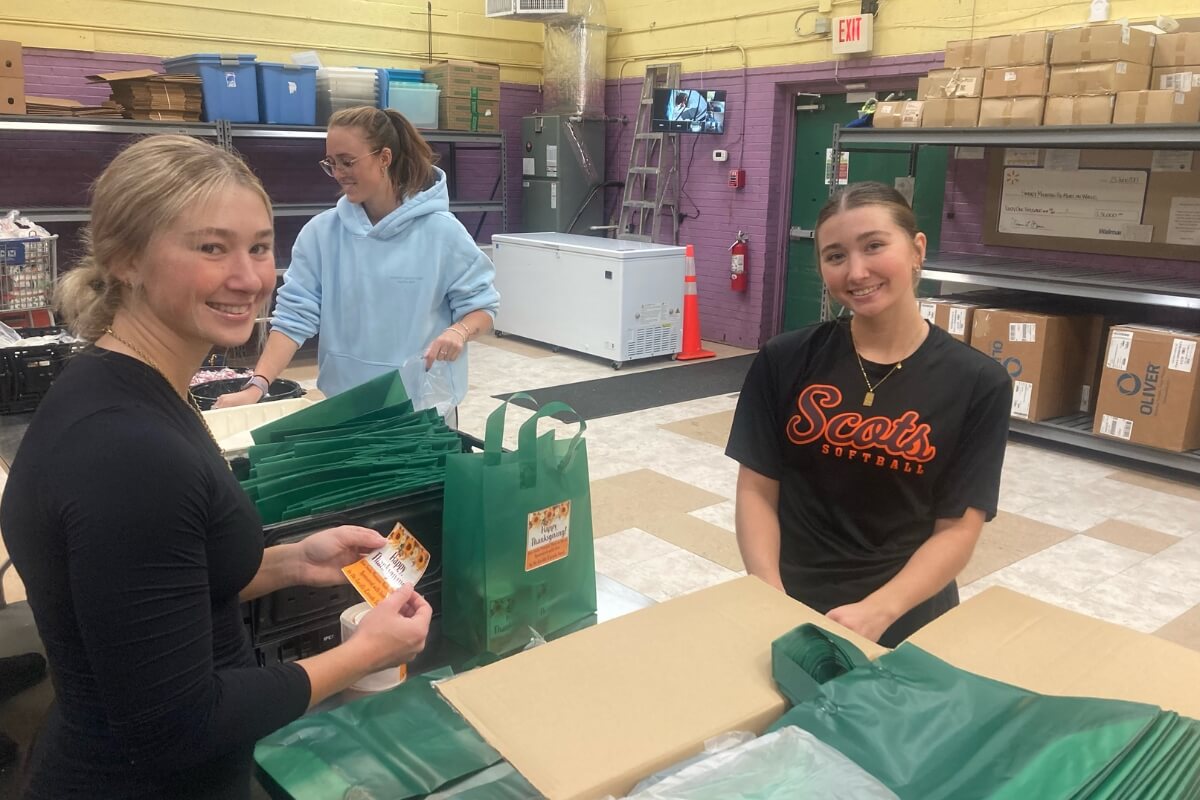 Photo of smiling Maryville College students packing mobile meal boxes