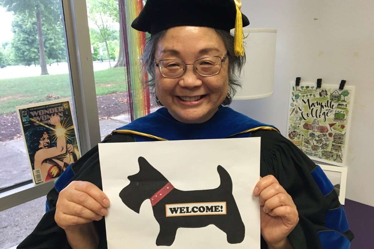 Photo of Dr. Kathie Shiba holding a welcome sign