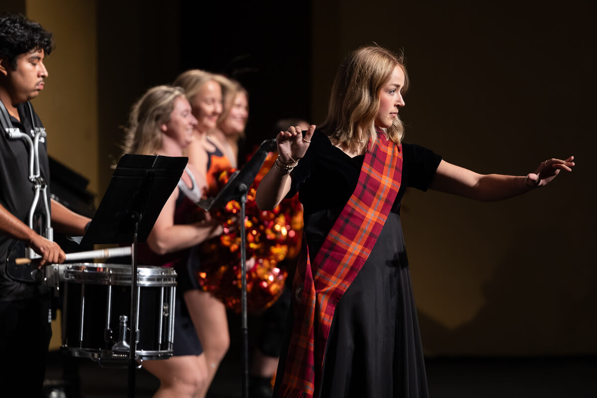 Photo of a student directing the MC Tartanband