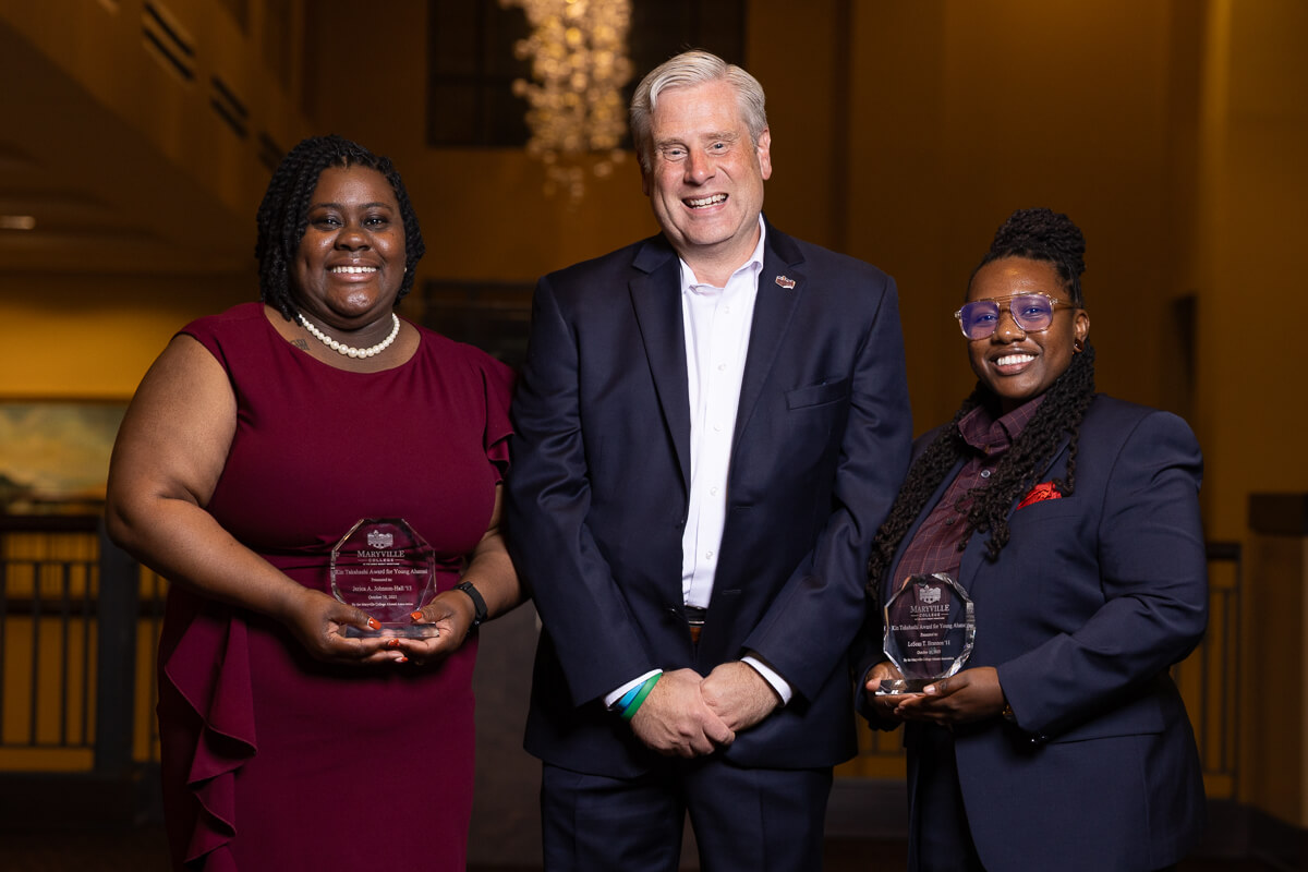 Photo of two Alumni Award winners on either side of Dr. Bryan Coker