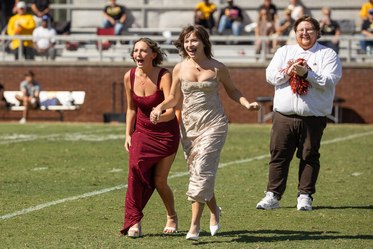 Photo of two excited girls on a football field after being named Homecoming Royalty