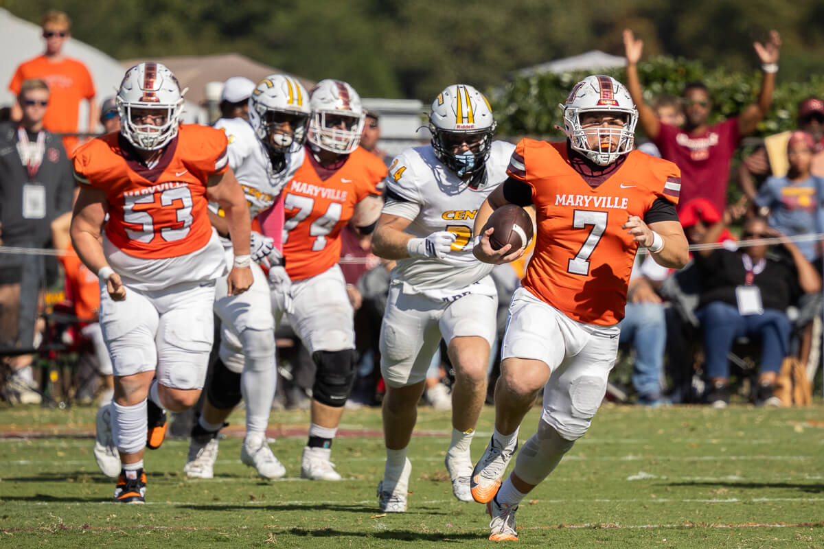 Photo of Maryville College football player running downfield being chased during Homecoming 2025